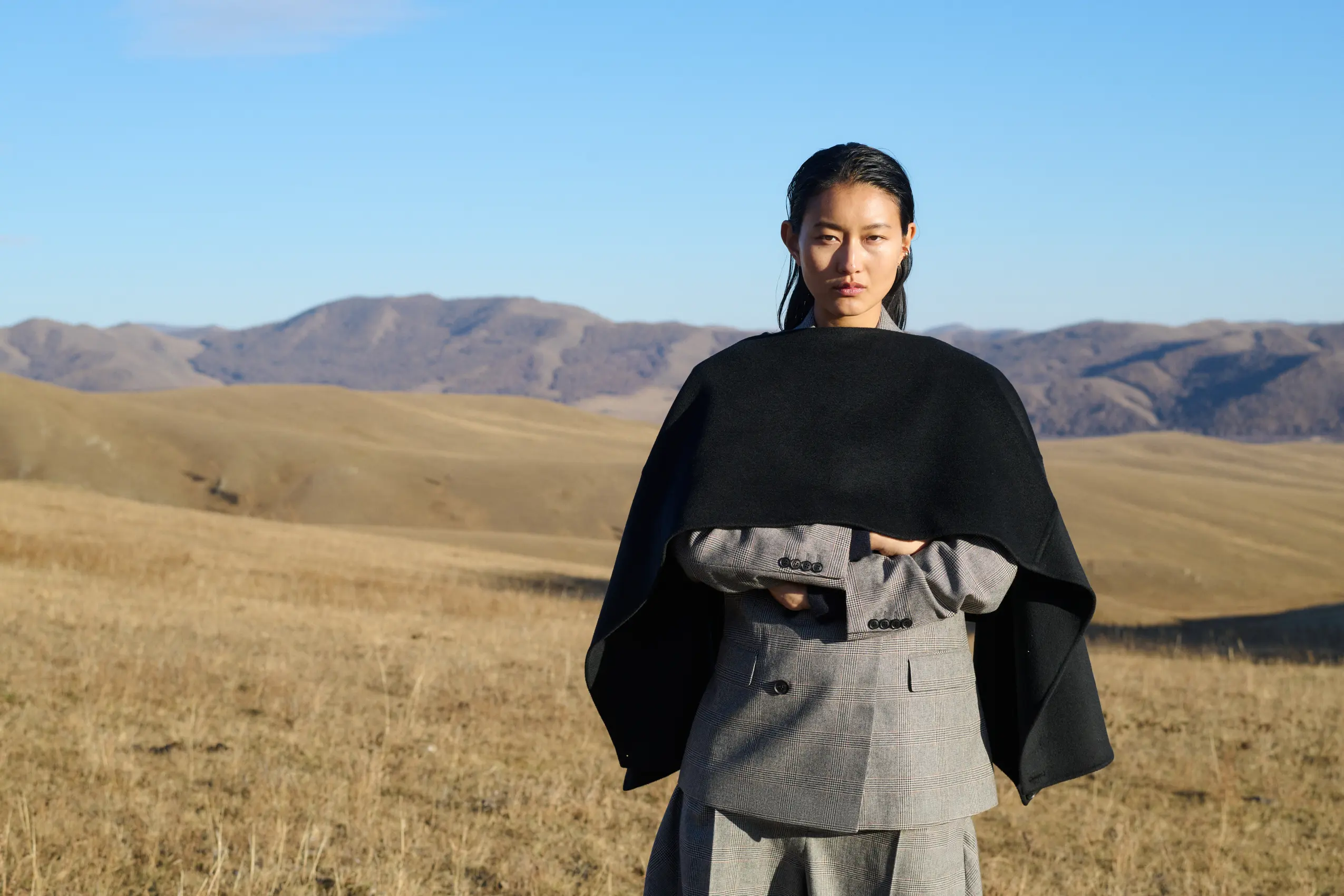 a woman wearing black cashmere poncho in scenic fall nature