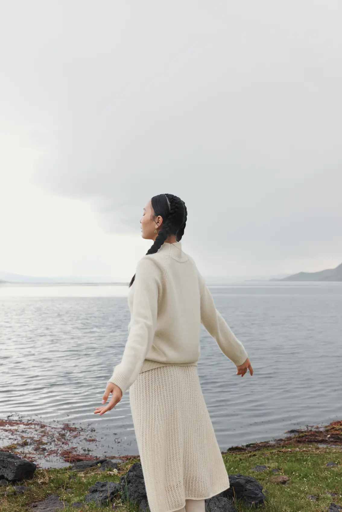Side view of a woman wearing full cashmere outfit immersed in lake scenery | GOBI Cashmere