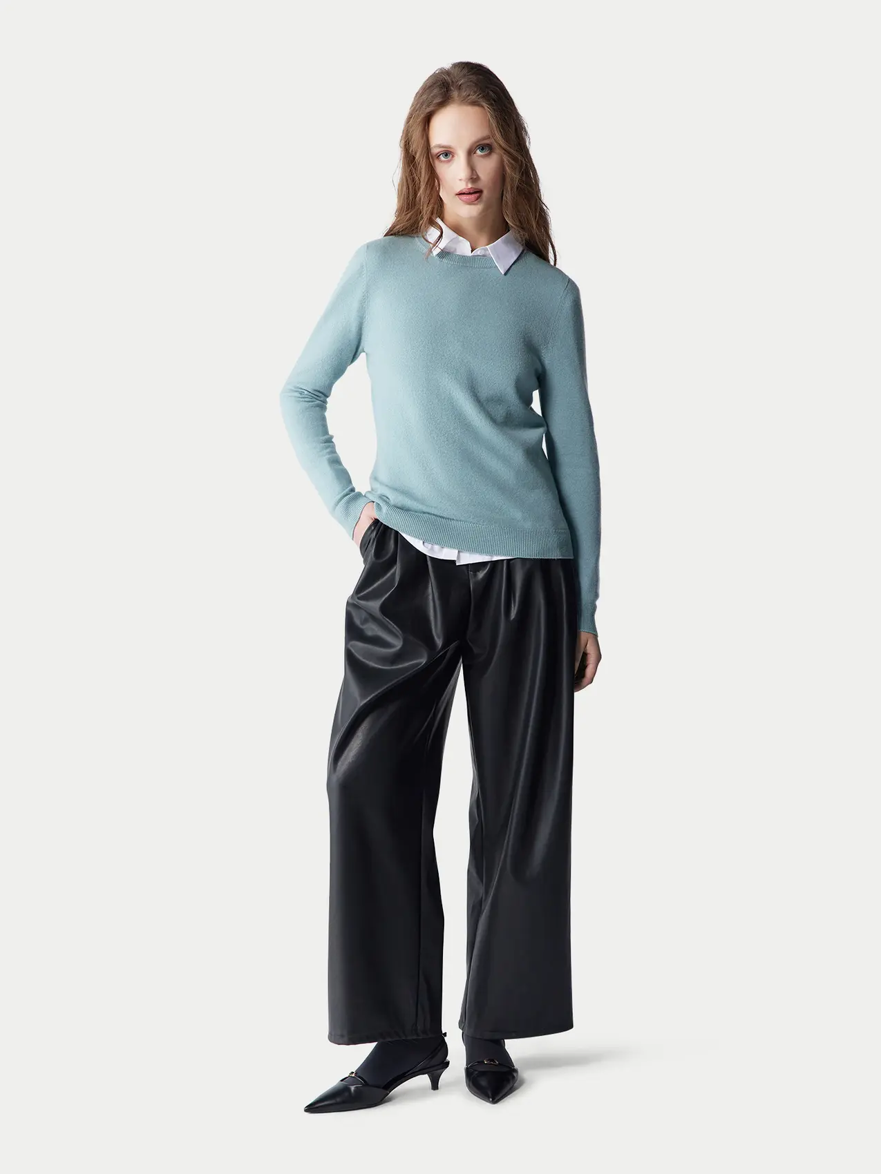 Women's casual look with powder blue cashmere crewneck sweater and black leather pants 