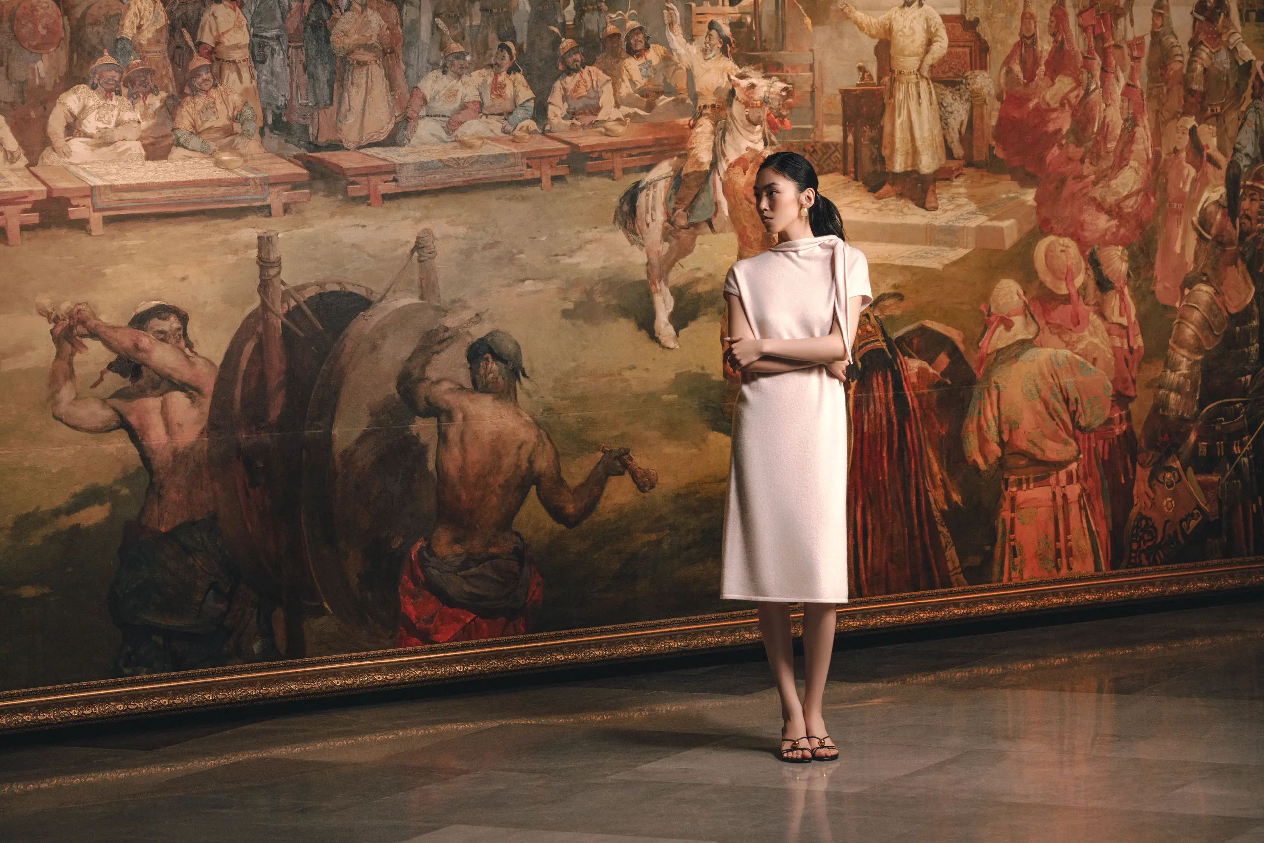 woman wearing baby pink cashmere midi dress with neck scarf standing in front of big Mongolian painting | GOBI Cashmere