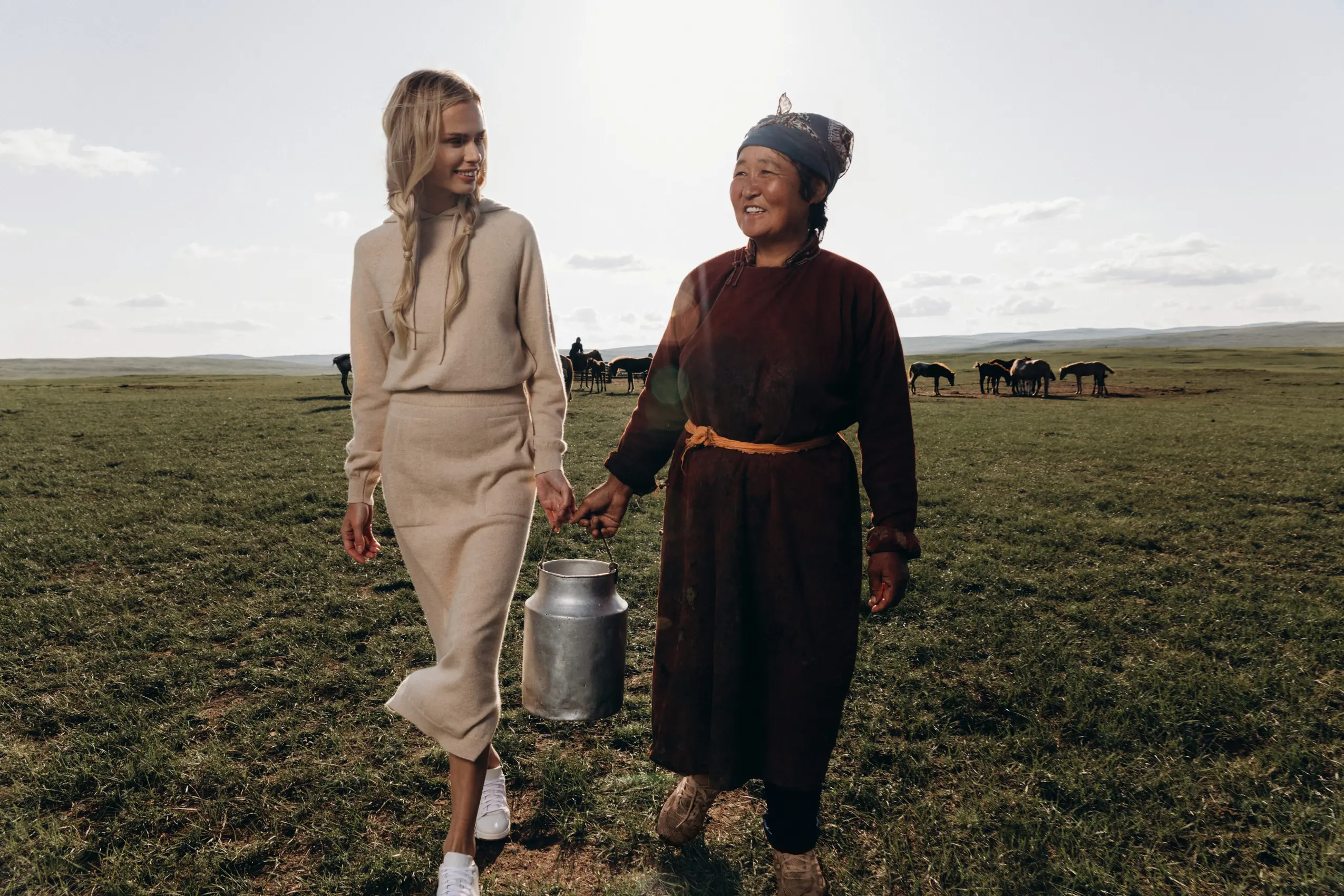 model holding bucket of milk with mongolian herder