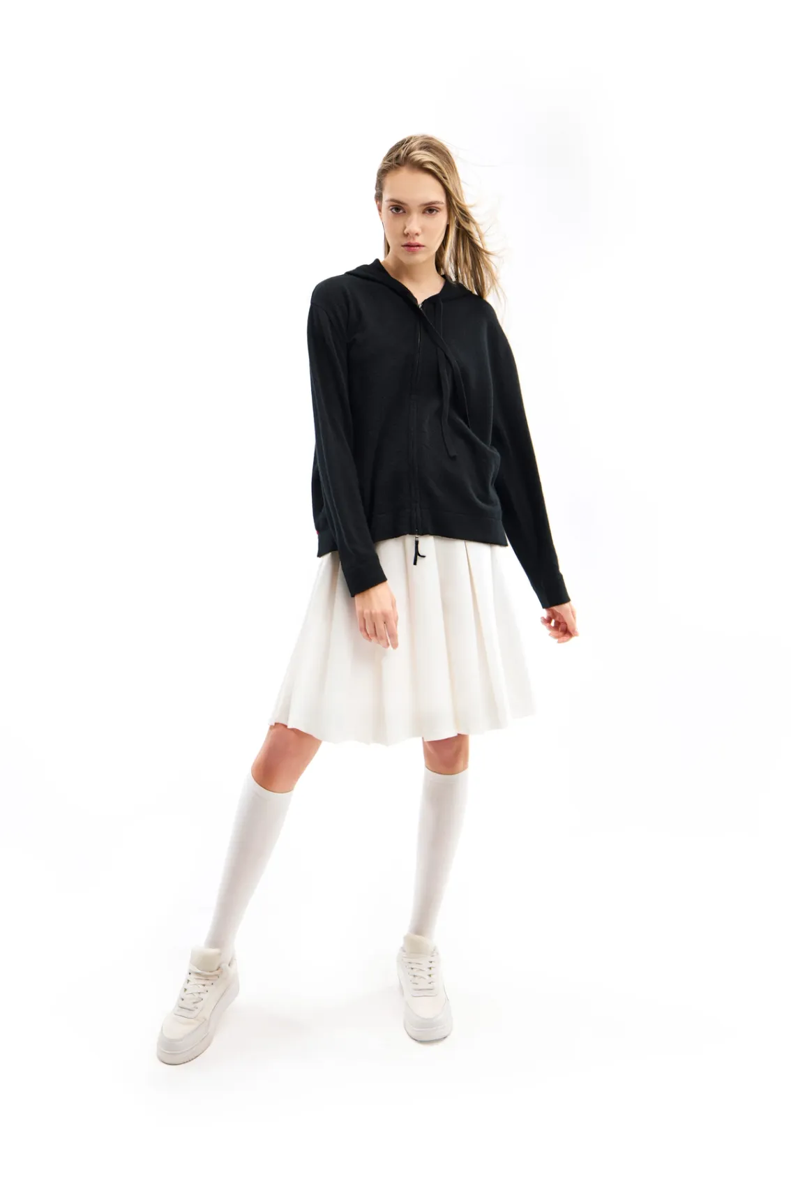 model wearing a cashmere hoodie and a white tennis skirt