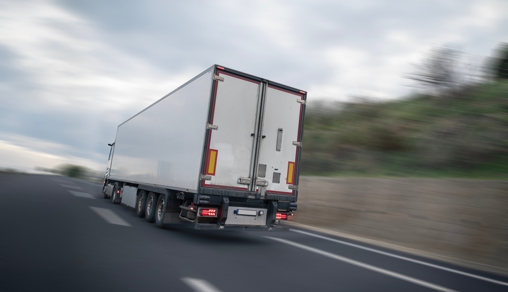 Image Semi truck driving on a South Jersey highway in winter conditions, showing how tailgating behind trucks increases crash risk on slick roads.