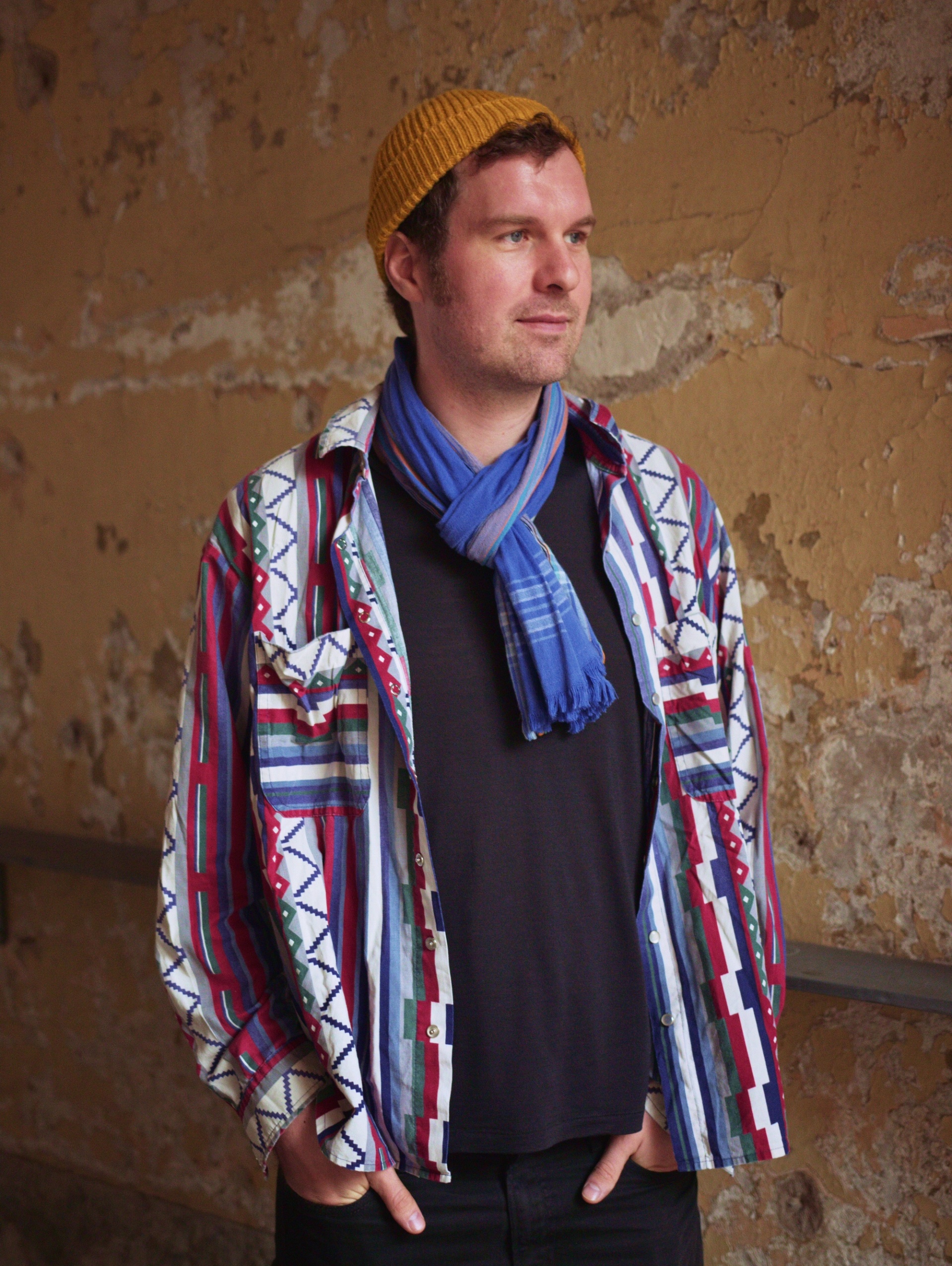 Man som tittar åt höger med händerna i fickorna