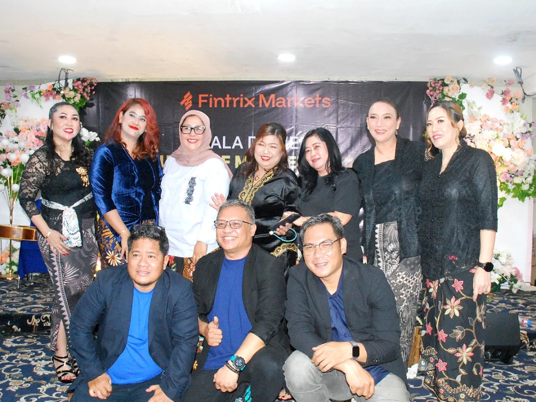 Guests pose in two rows in front of a floral display and Fintrix Markets gala dinner backdrop.