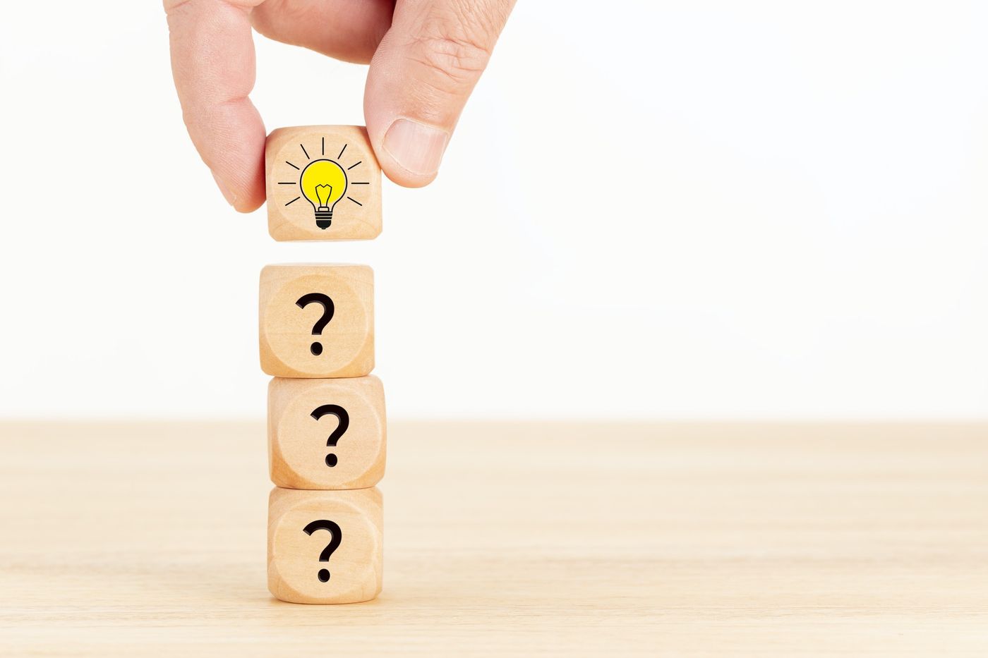 PickFu and MBA students: Stack of wooden cubes printed with question marks and a light bulb icon