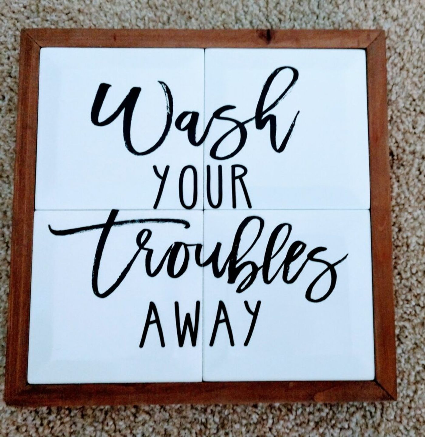 Option A: a tiled sign reading Wash your troubles away in a wooden frame