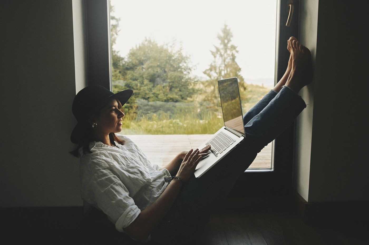How to get reviews on Amazon: Young woman in hat browsing laptop, shopping or working online from home