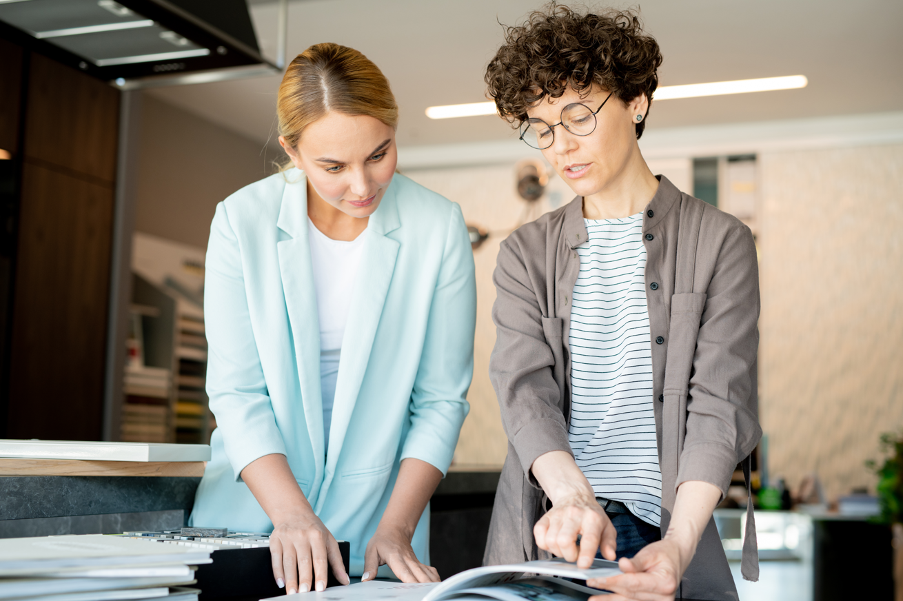 Candid stock photo of two women reviewing a catalog together