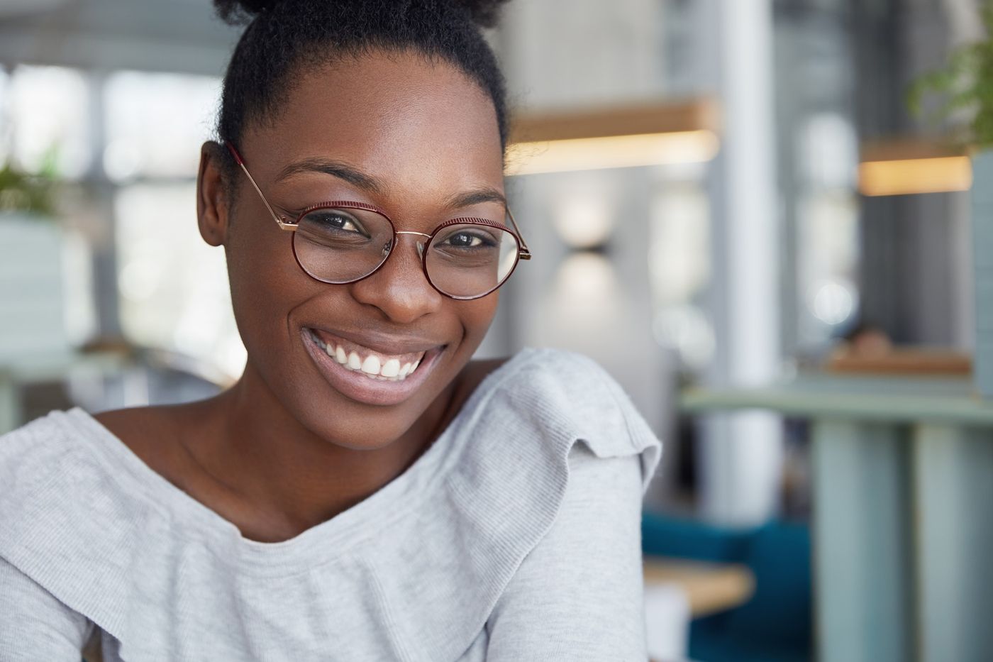 Best LinkedIn profile and cover photos: headshot of smiling Black female in round glasses