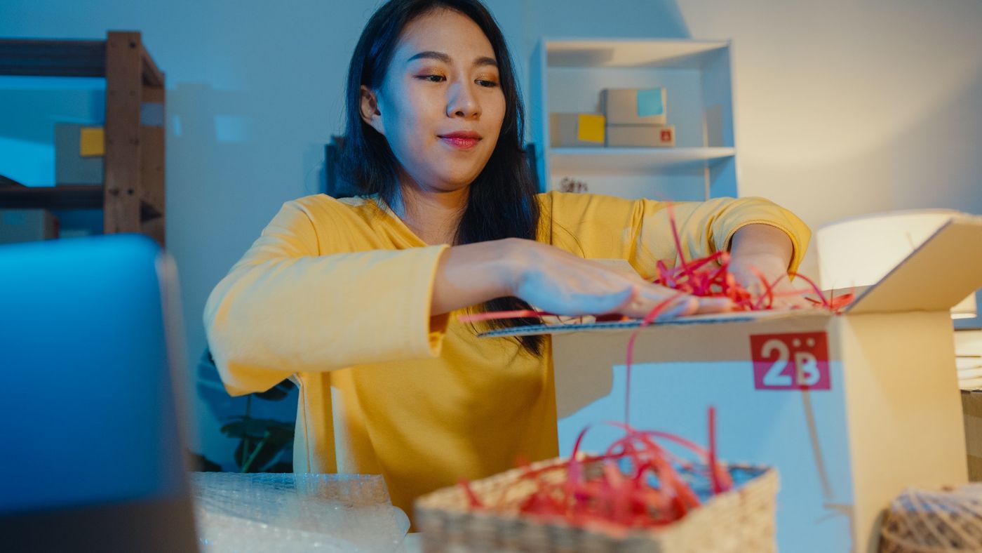 Top tips to selling on eBay: woman packing a box to ship