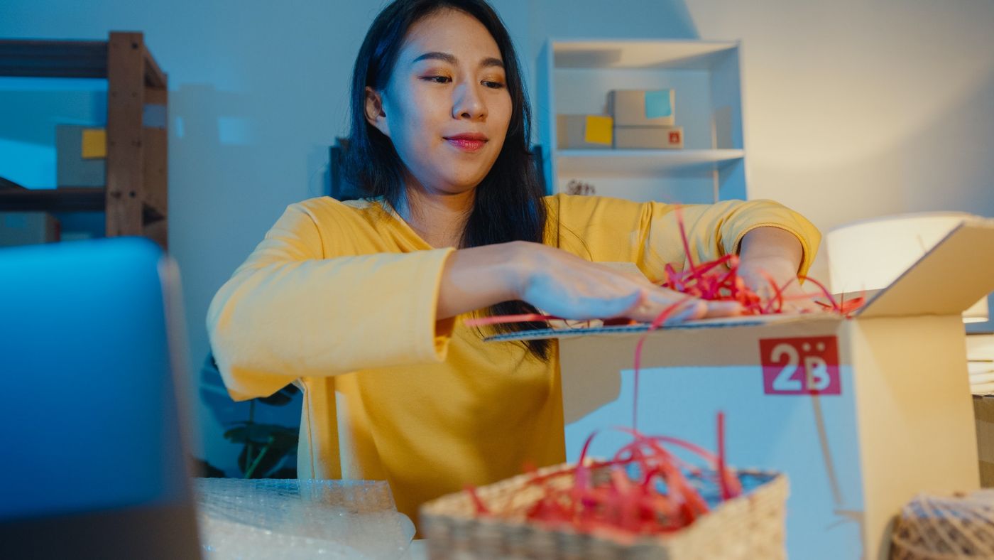 Top tips to selling on eBay: woman packing a box to ship