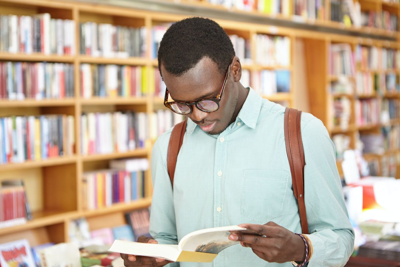 How to get reviews on Amazon: young man reading a book in a bookstore