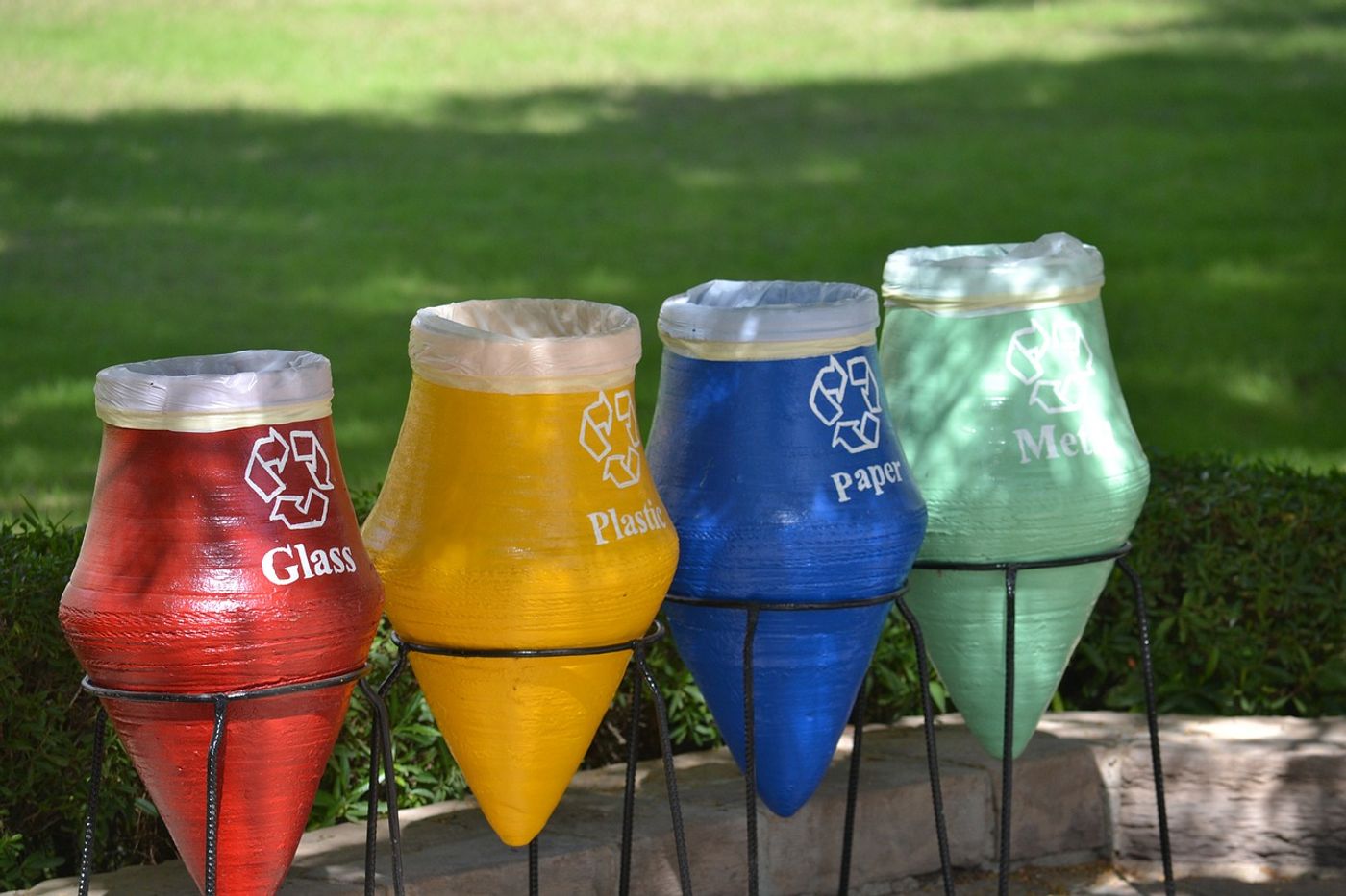 A photo showing four recycling bins of different colors.
