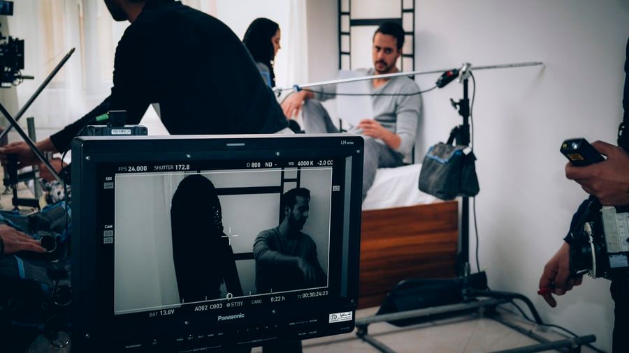 A group of people doing a photoshoot in a white room and editing images.