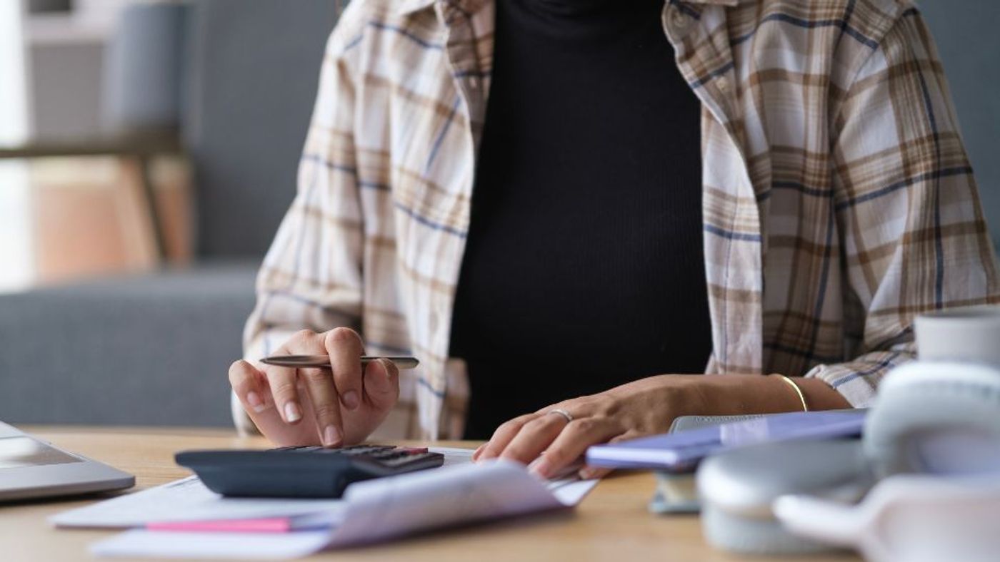 A person doing account to calculate their costs - Canva
