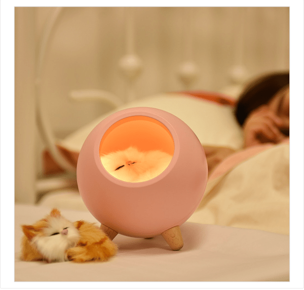 Pet night light shaped like a cat in a ball glowing on a bedside table