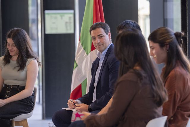 Participantes conversando junto a la ikurriña