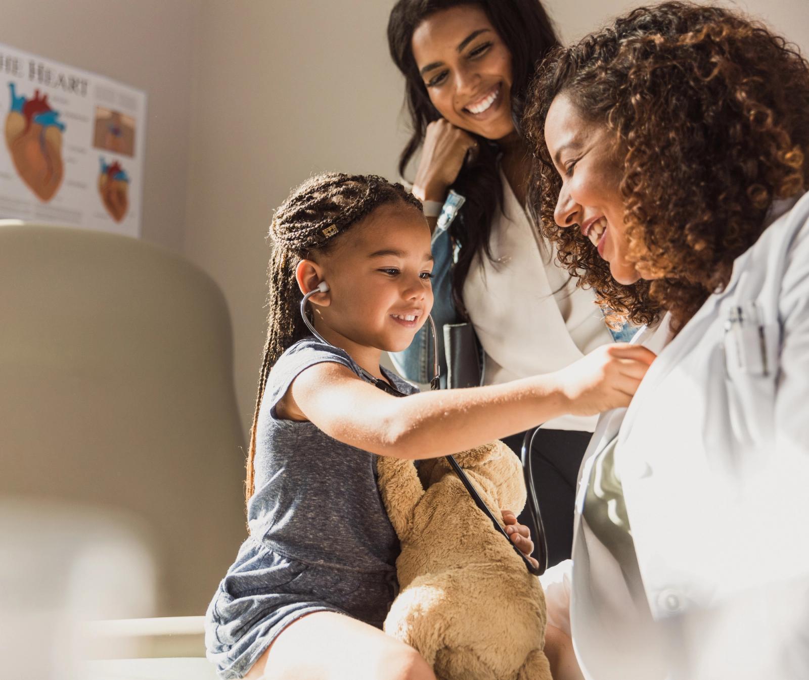 Community health worker checking a child’s health with her family