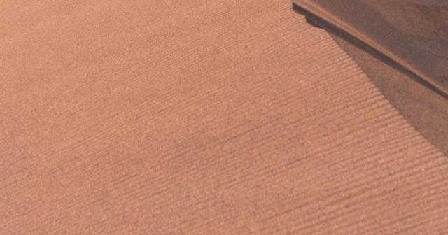 A sunlit dune ridge separates golden sand from a deep shaded slope.