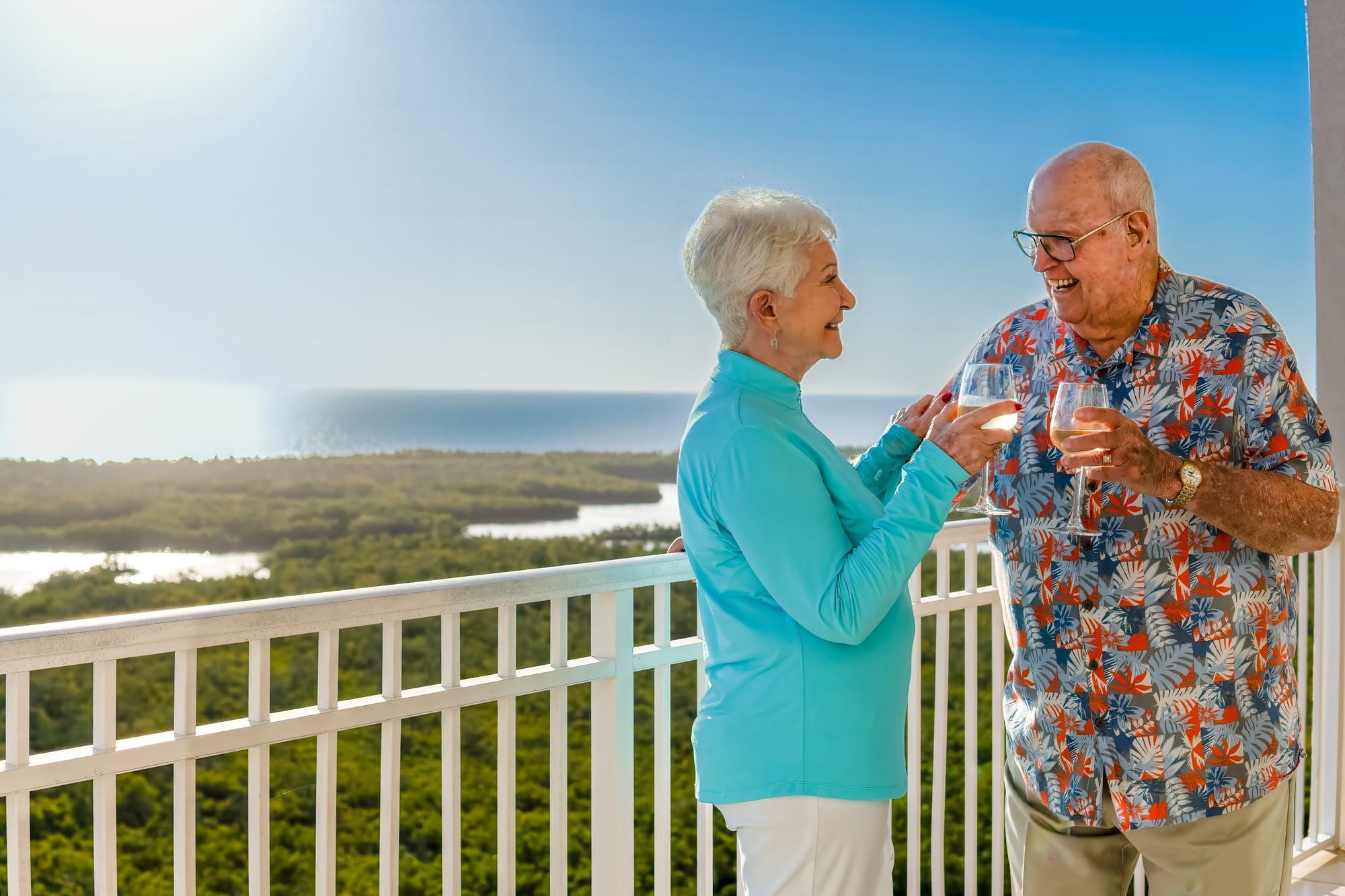 Residents toasting on a waterfront balcony