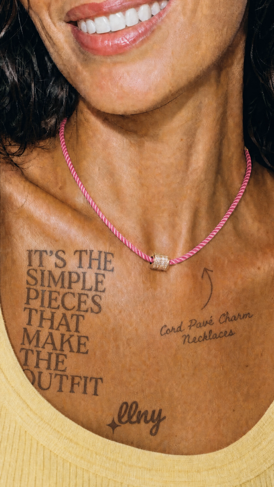 Woman wearing a LLNY cord charm necklace with the caption It's the Simple Pieces that Make the Outfit tattooed on her clavicle.
