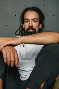 Jan Haiko laughing in front of a climbing wall.