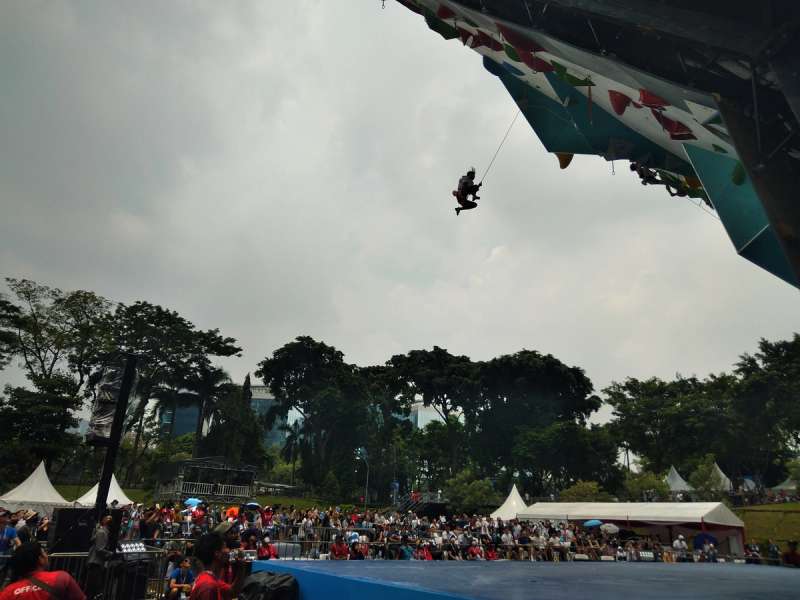 A person falling into the rope at a lead climbing competition.