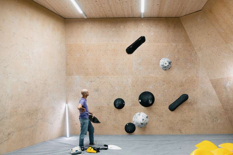 Matthias Woitzuck looking at a climbing whole, hands resting on his hips.