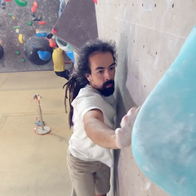 A person doing a dynamic move to the side in order to reach the next hold.