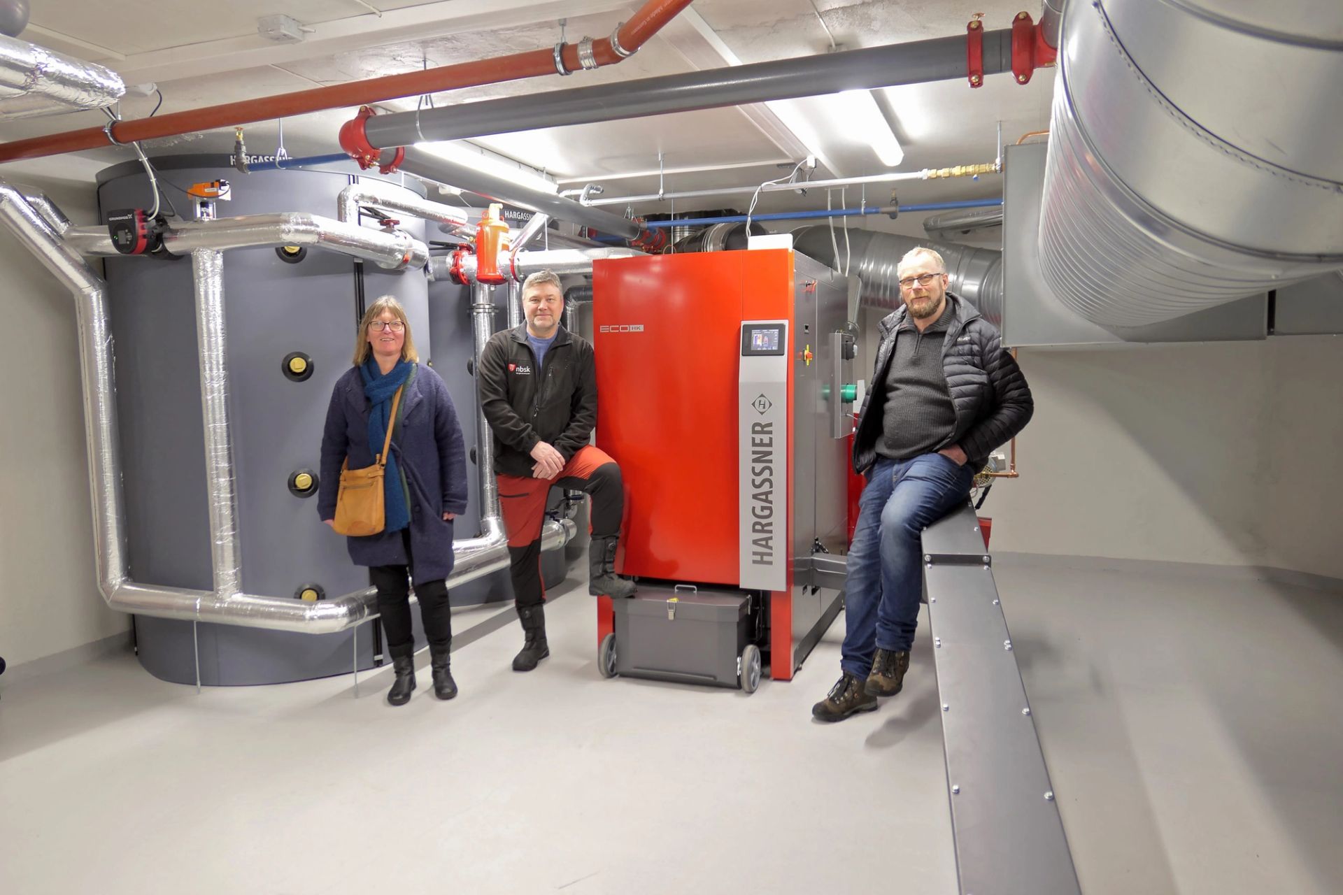 Eli Samuelsen og Geir Pedersen i Tinn kommune kommer gjerne på visitt i fyrrommet på ærverdige Mandheim.Jon Lilleland t.h. legger penger og prestisje i å bygge solid og pent. Det gir biovirke-næringen et godt rykte.