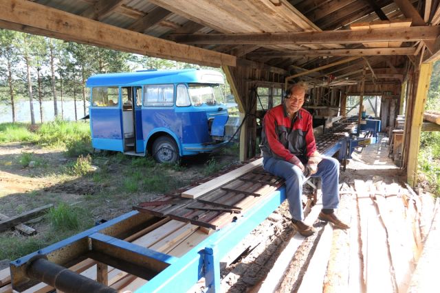 Nils Belland med hans trofaste arbeidskamerat i bakgrunnen. Med hjelp av bussen kan Nils skjære de lengdene han selv ønsker.