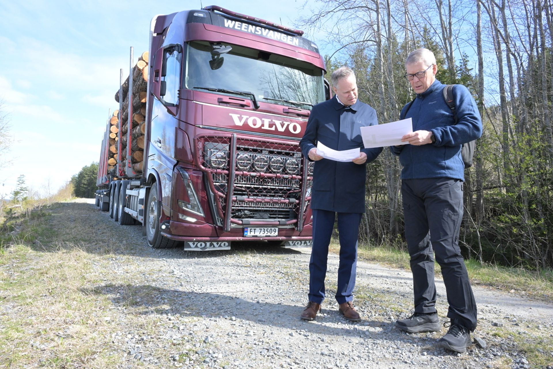 Samferdselsministeren fikk innføring i prøveordningen fra Skogeierforbundets rådgiver Dag Skjølaaas. Tømmerbilen i bakgrunnen har ni aksler og kan lastes med en totalvekt på 74 tonn fram til 30. juni. Da skal prøveordningen avsluttes. Foto: Roar Ree Kirkevold.