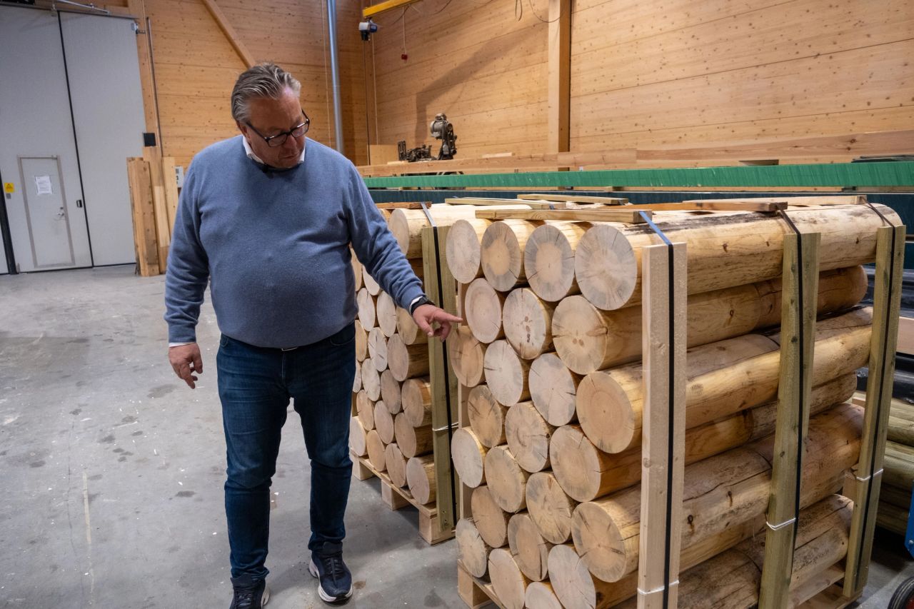 Gunnar-Adolf Aanesland viser fram ferdig dreide rundstokker i fabrikken til Aanesland Treindustri.