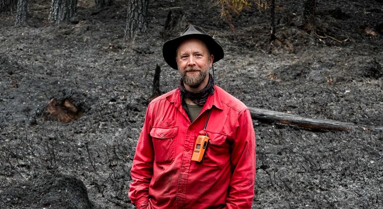 Johan Falck står på den sotsvarte brannflaten. Om et par år vil den igjen være grønn. I mellomtiden er det en del sopp og innsekter som trives ekstra godt.