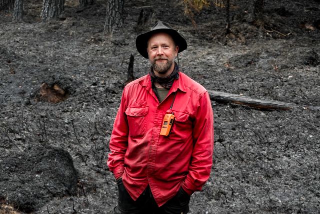 Johan Falck står på den sotsvarte brannflaten. Om et par år vil den igjen være grønn. I mellomtiden er det en del sopp og innsekter som trives ekstra godt.