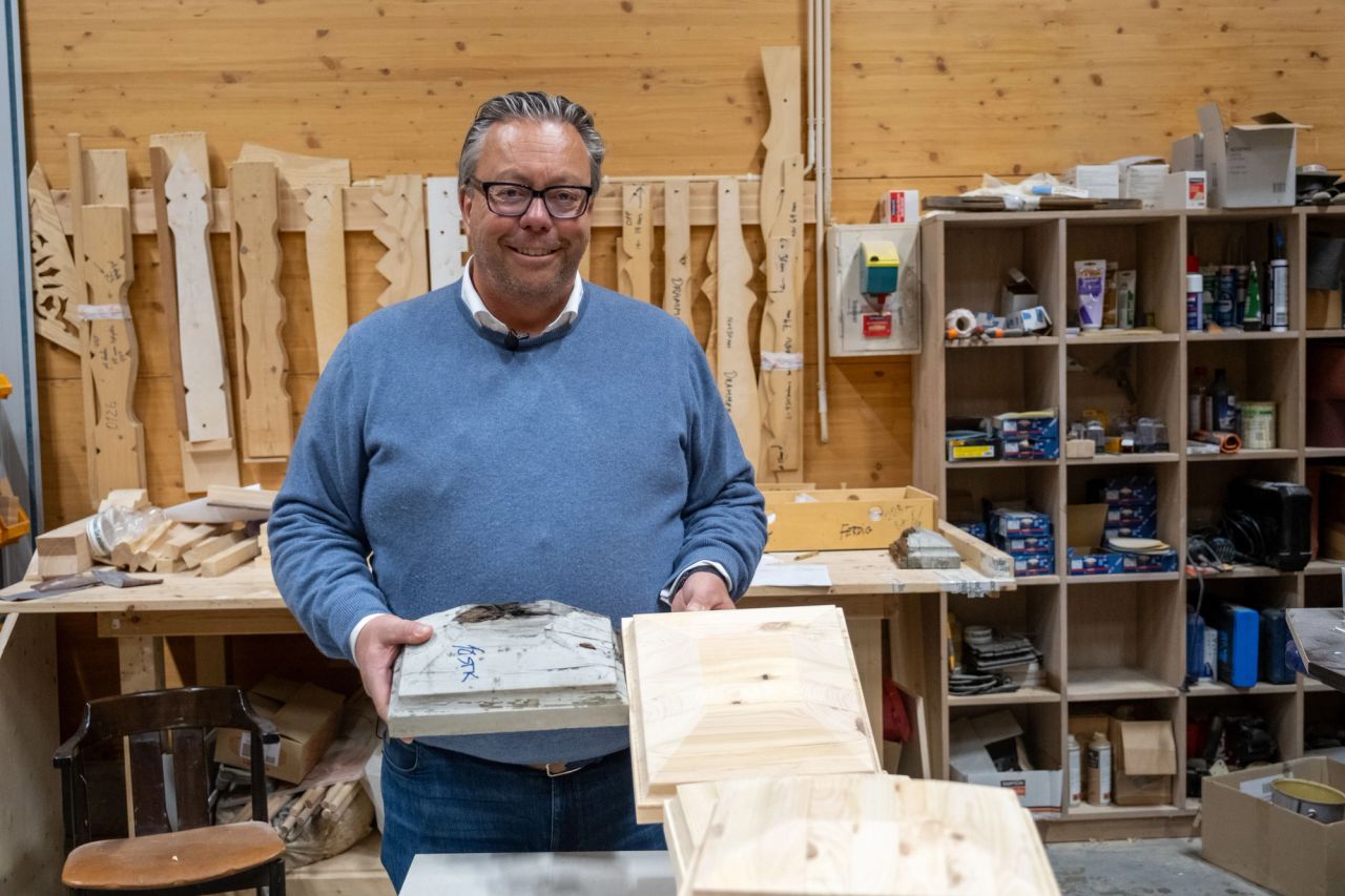 Gunnar-Adolf Aanesland holder fram to ulike treplater inne i fabrikken.