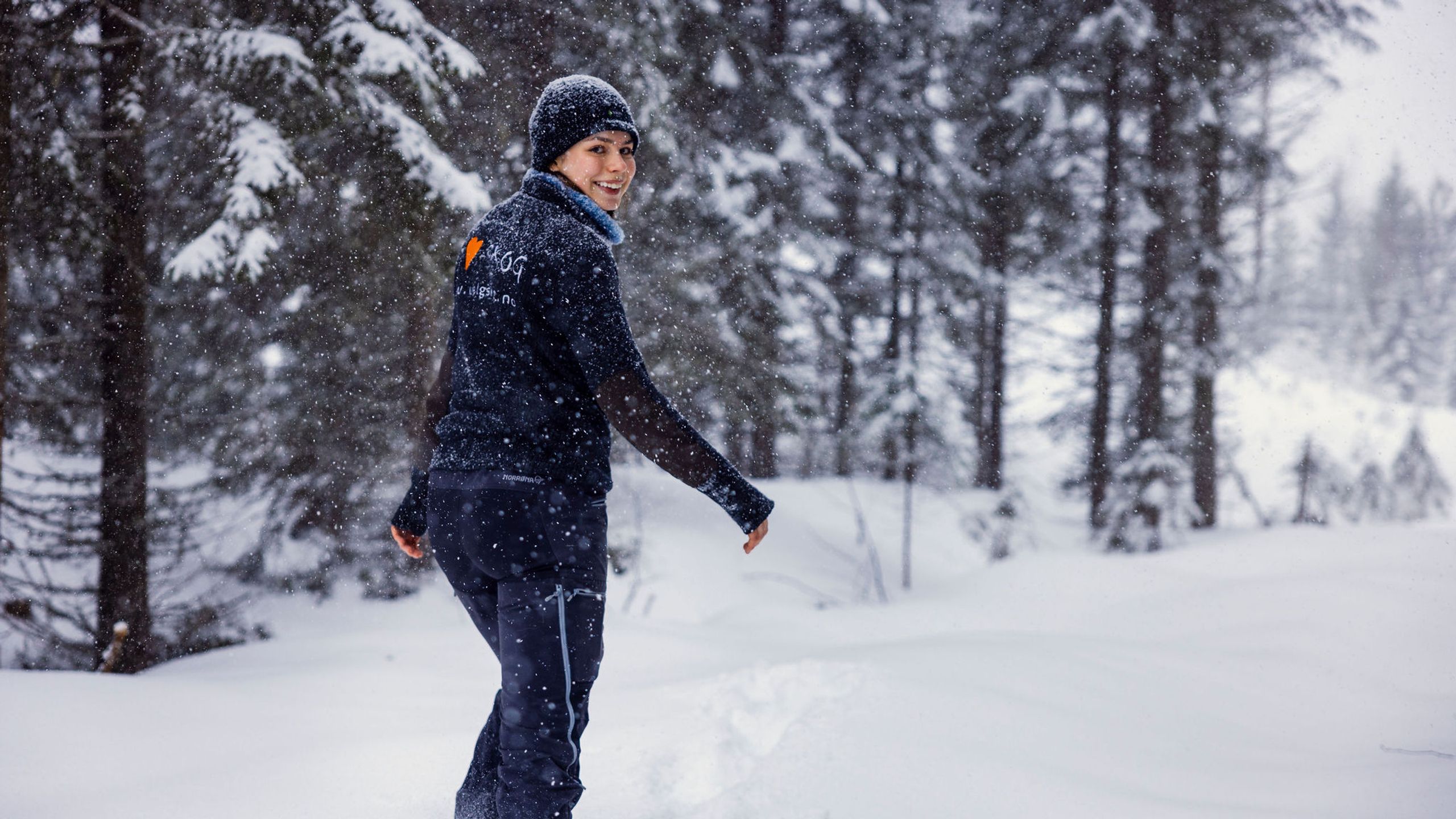 Viil Flaata går gjennom snødekt skog mens det snør tett.