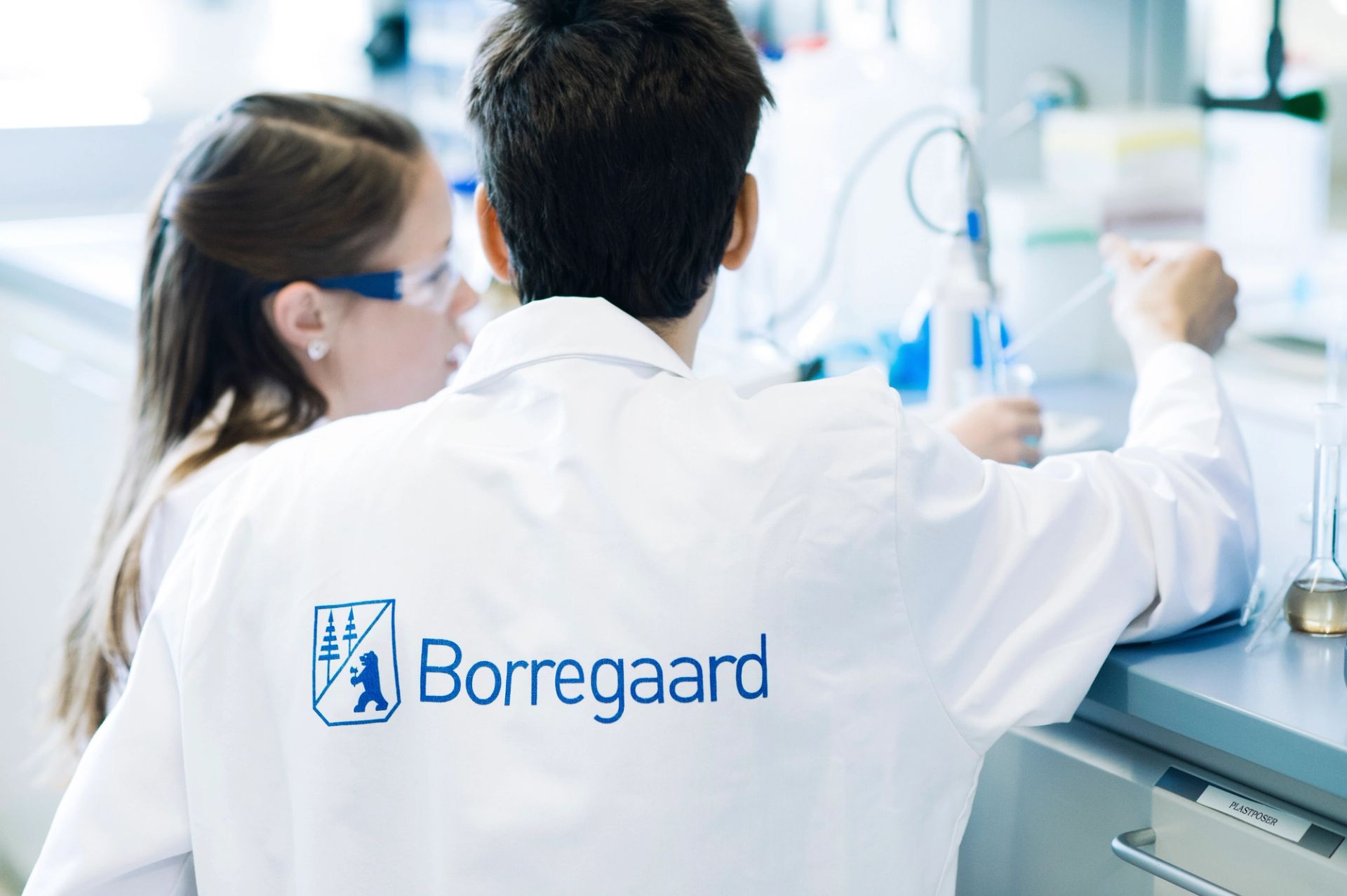 To ansatte i hvite laboratoriefrakker arbeider ved en laboratoriebenk hos Borregaard.