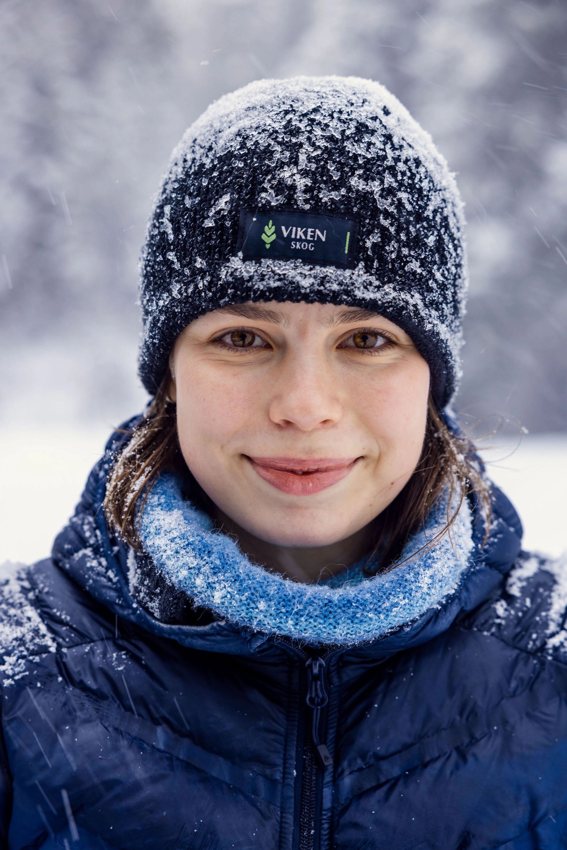 Portrett av Viil Flaata med snødekt Viken Skog-lue i vinterlandskap.