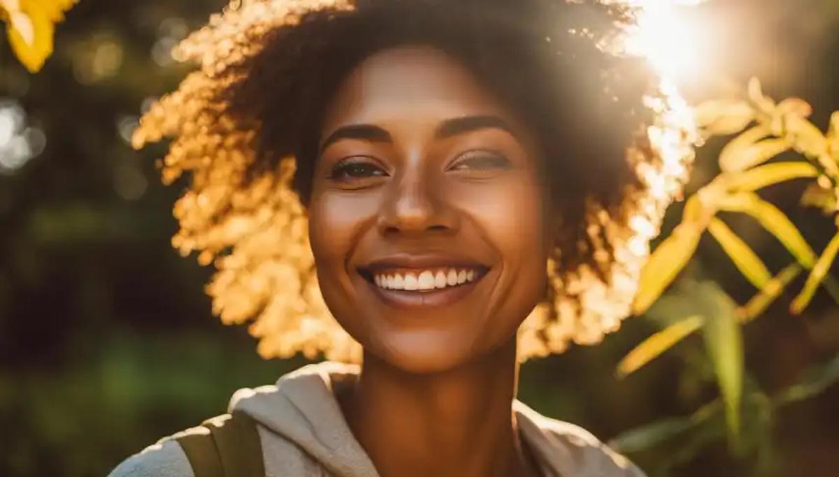 A person standing outside on a sunny day, with their face tilted up towards the sun