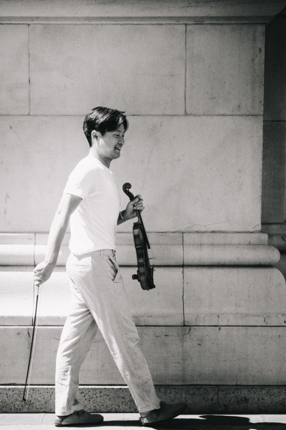 Siwoo Kim by a stone wall in New York