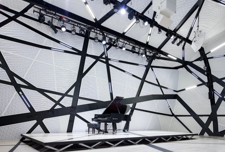 The hall at National Sawdust, Brooklyn: white faceted panels, black struts and a Steinway on the stage