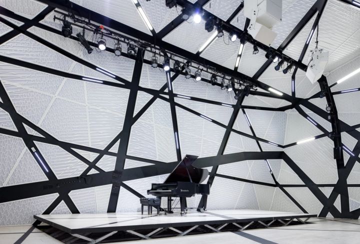 The hall at National Sawdust, Brooklyn: white faceted panels, black struts and a Steinway on the stage