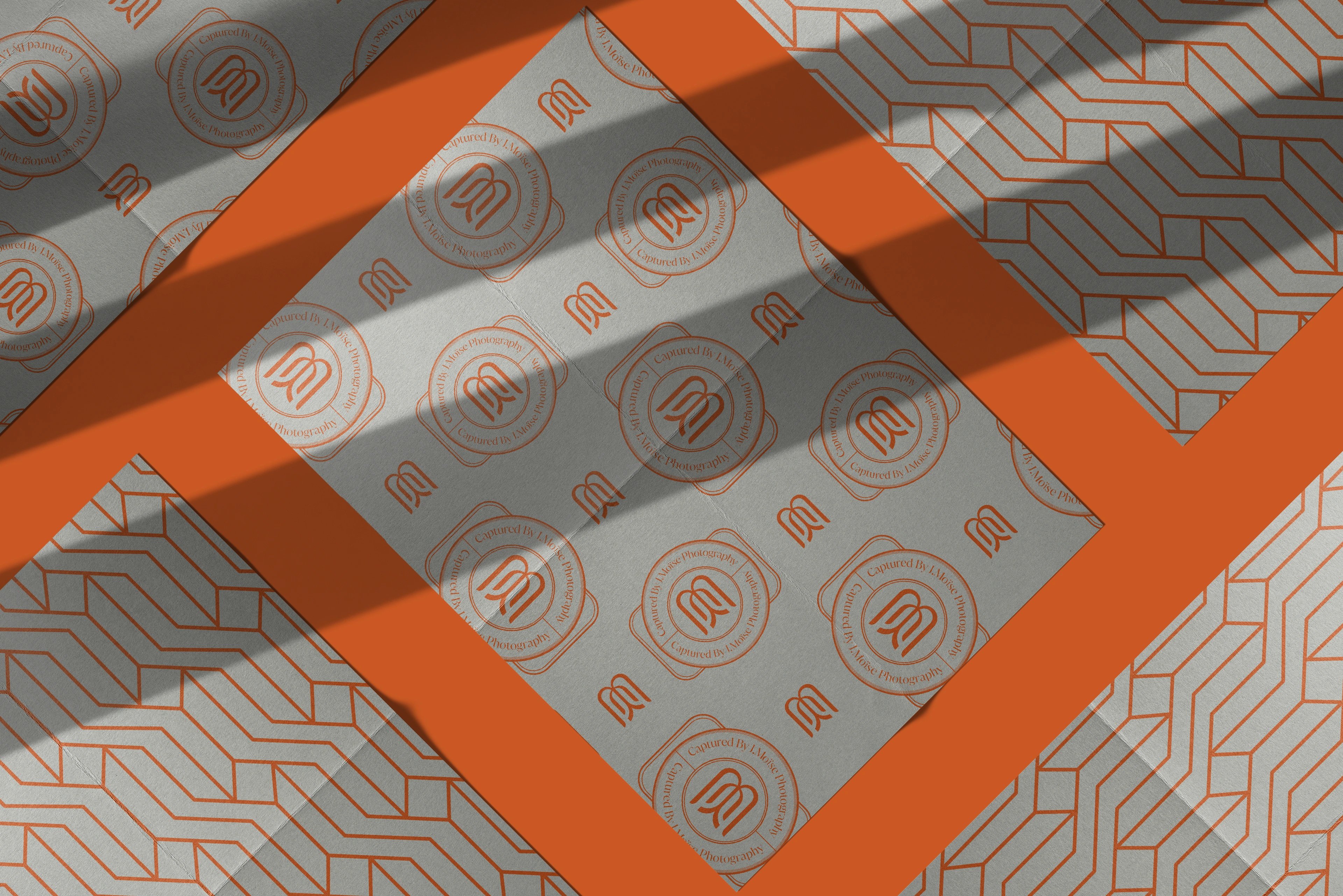 Captured by J. Moïse seal-and-monogram pattern printed on tissue with a burnt-orange ribbon
