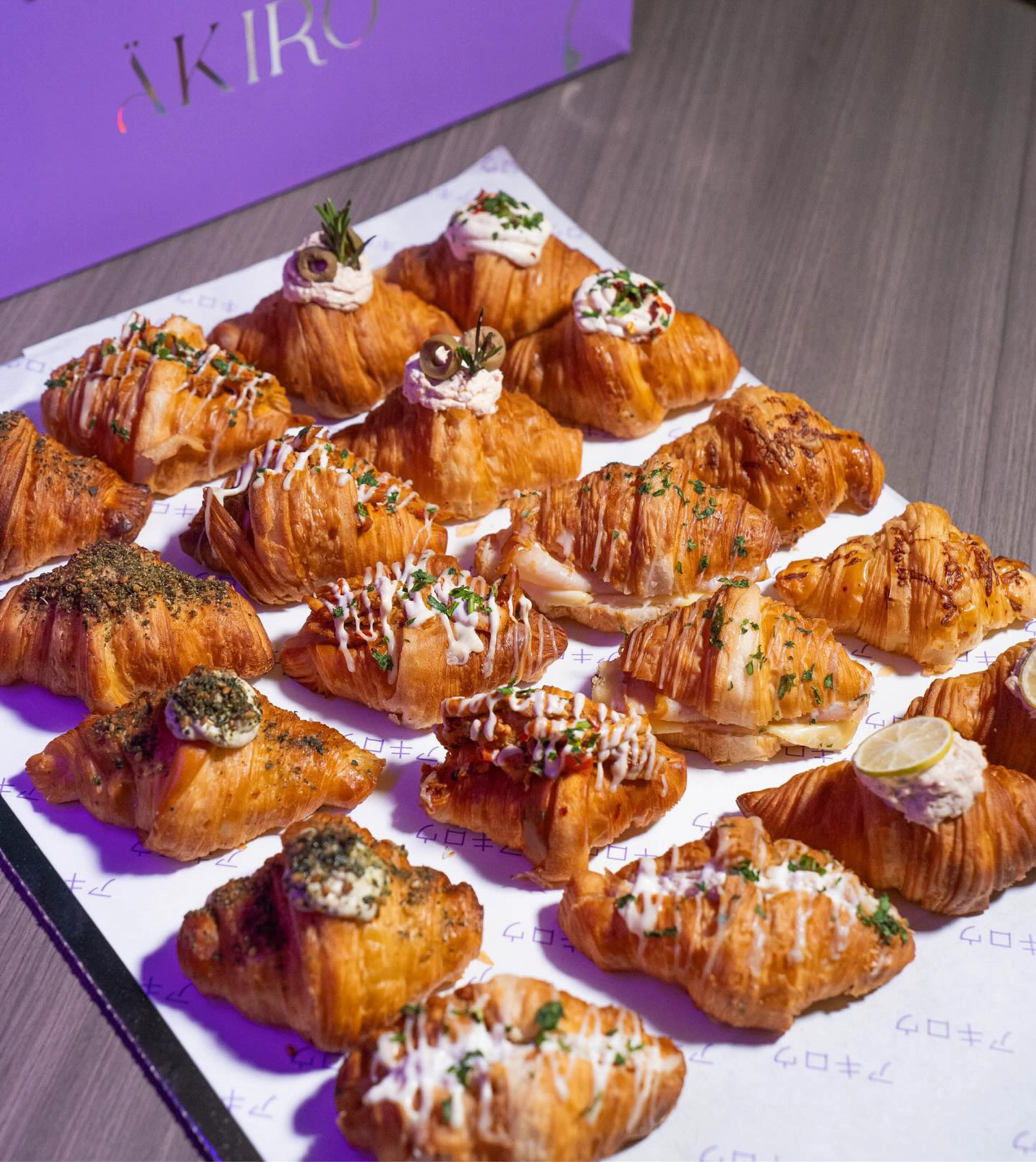 Purple ÄKIRO tray lined with glazed mini croissants
