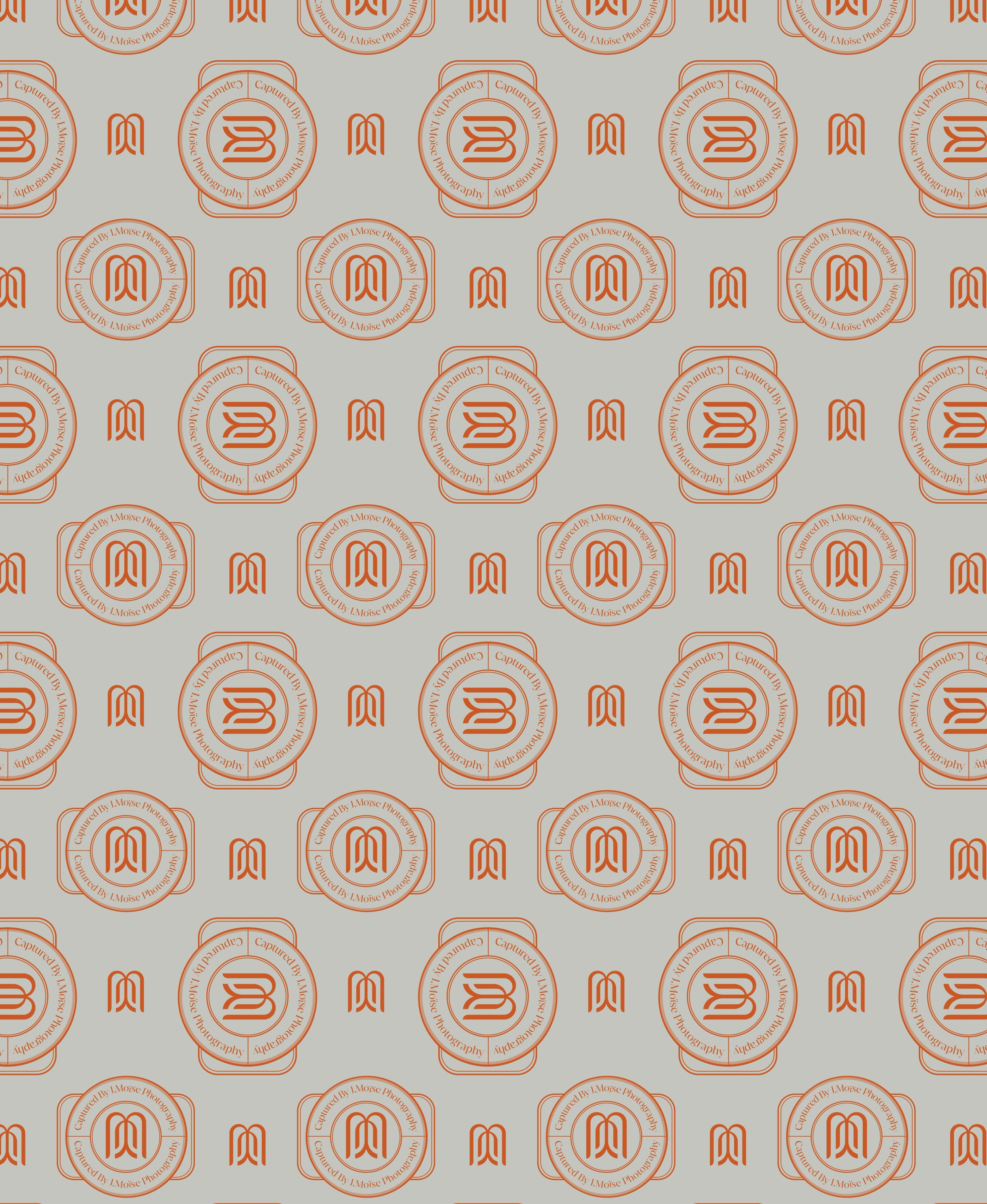 Captured by J. Moïse seal-and-monogram pattern repeated in burnt orange on a sage-grey ground