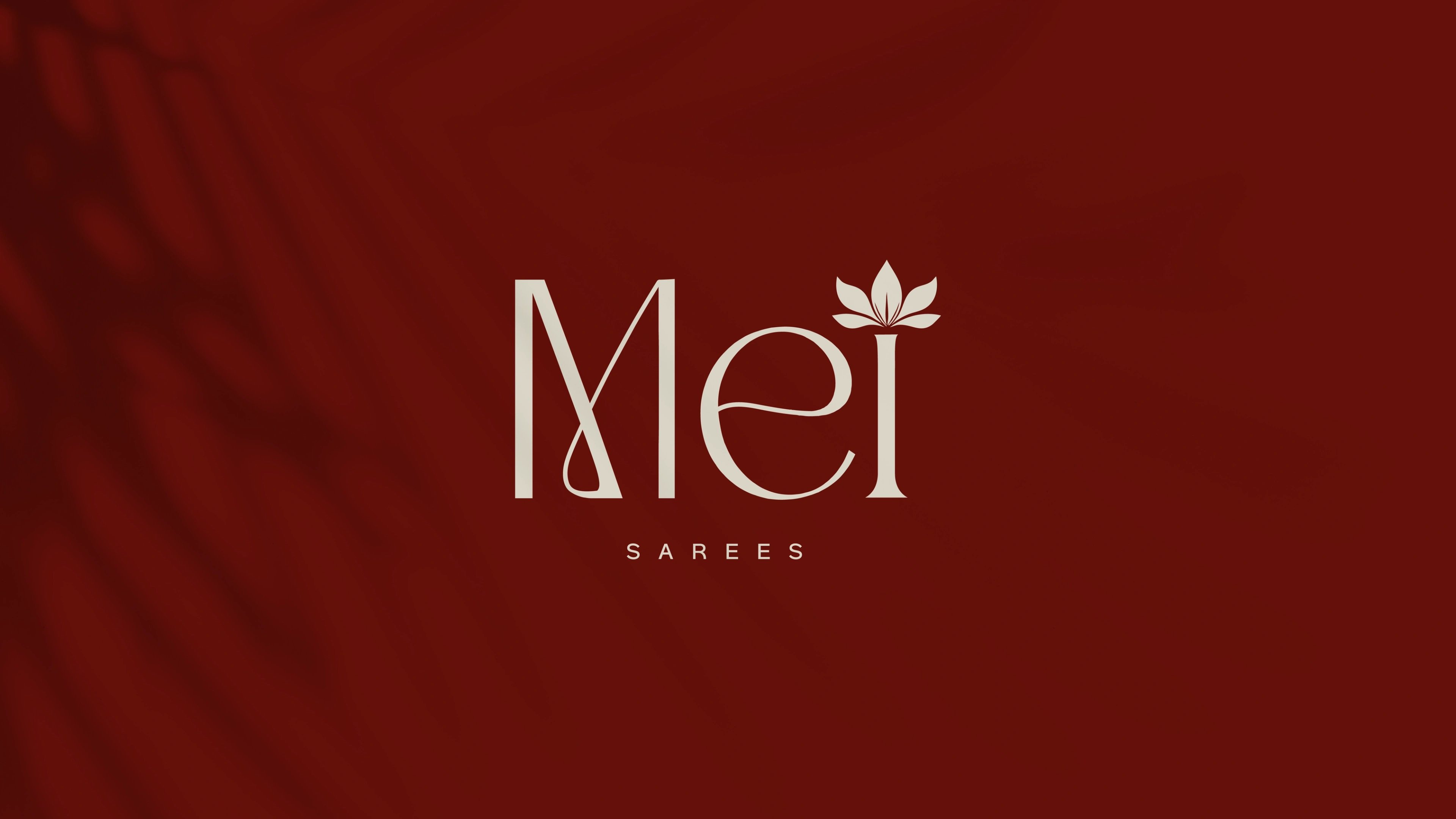 Mei sarees wordmark with a lotus bloom, cream on deep maroon