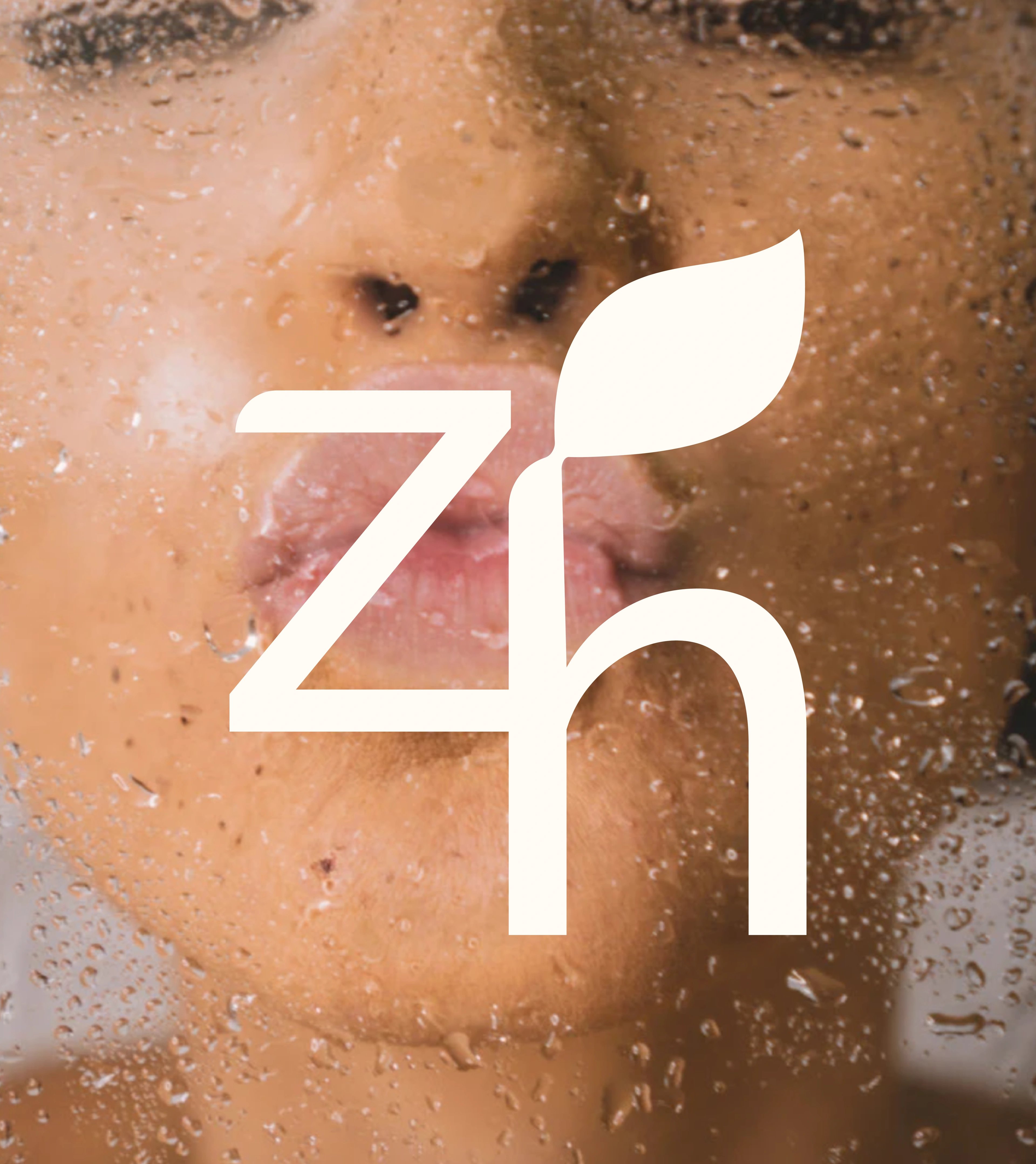 Zion Health zh leaf monogram set large over a close-up of water-beaded skin