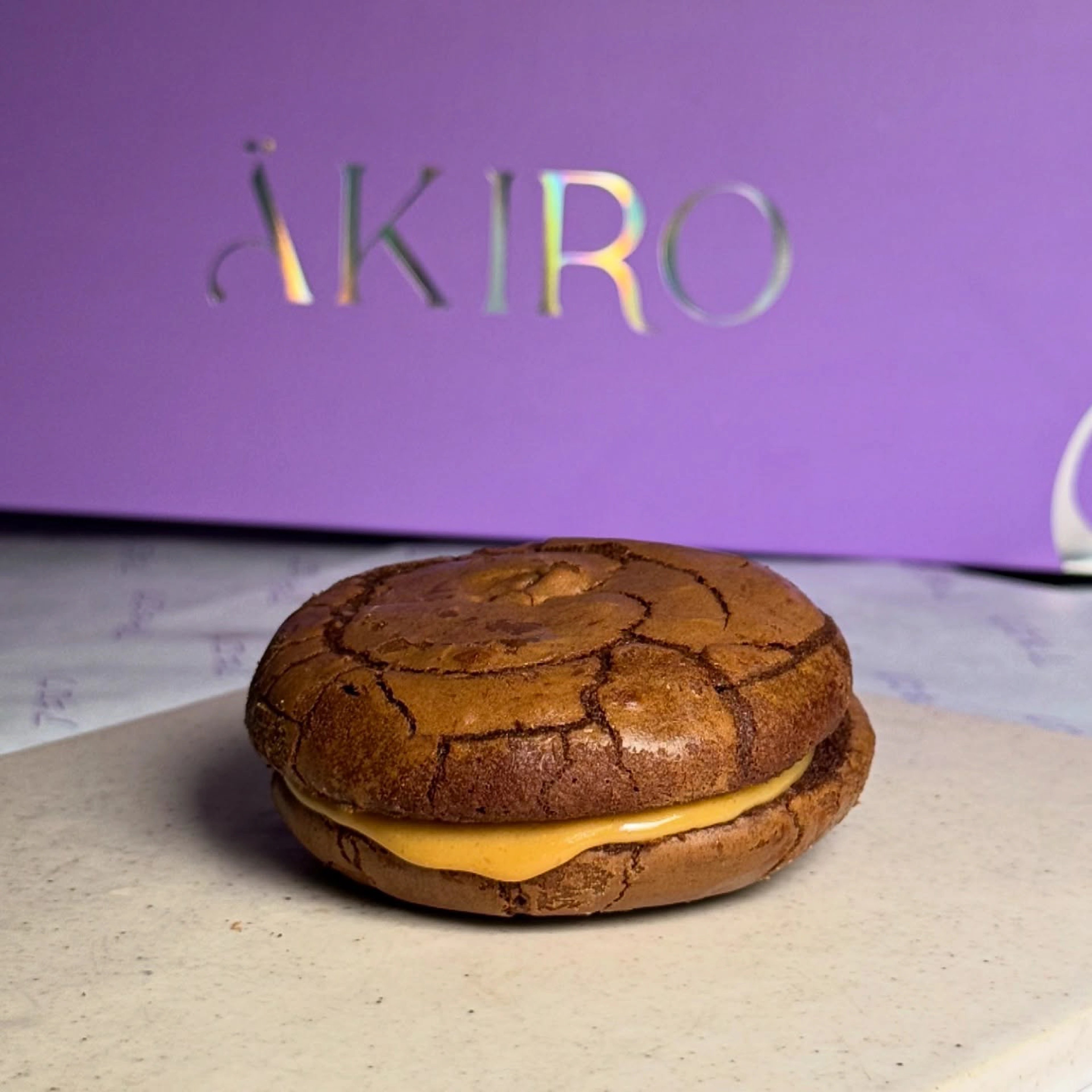 ÄKIRO wordmark beside a cracked-sugar bun on a plinth